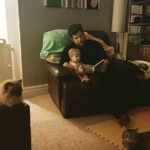 Mike reading a book to his son Theo